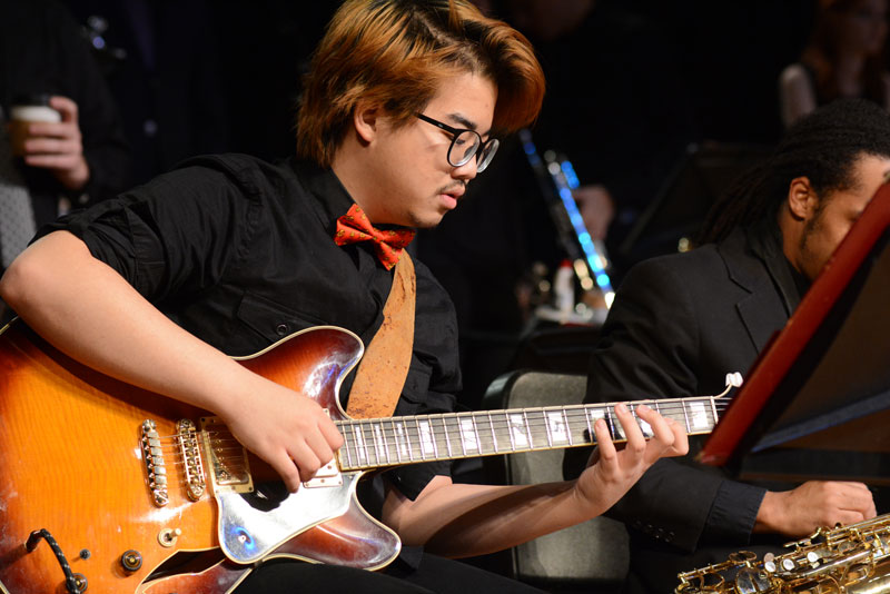 A student playing electric guitar in jazz band