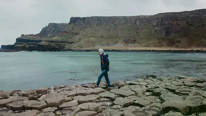 Male student walking down the Giant's Cosway in Northern Ireland