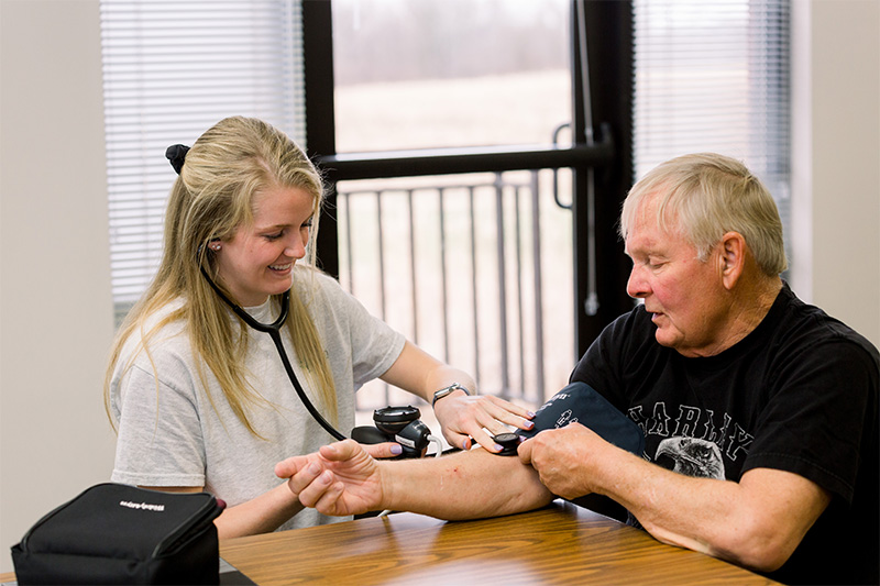student taking a man's blood pressure