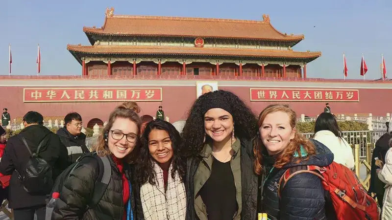Four female students standing in front of The Forbidden City in China.