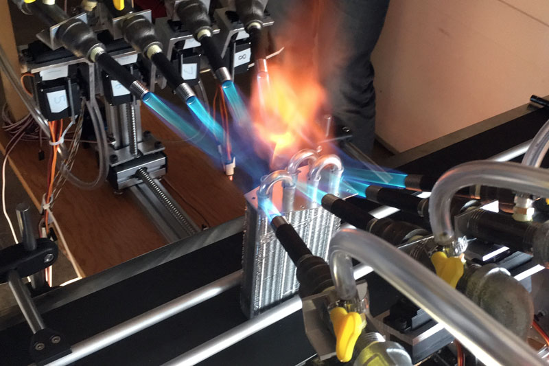 A series of eight burners heating up some metal