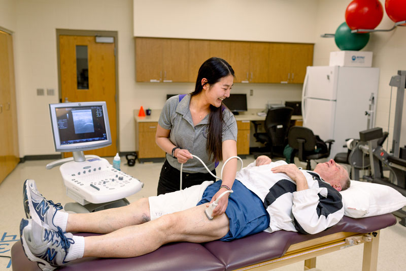 A student using a device on a man's leg