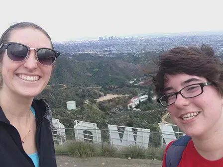 Two female students taking a selfie behind the Hollywood sign