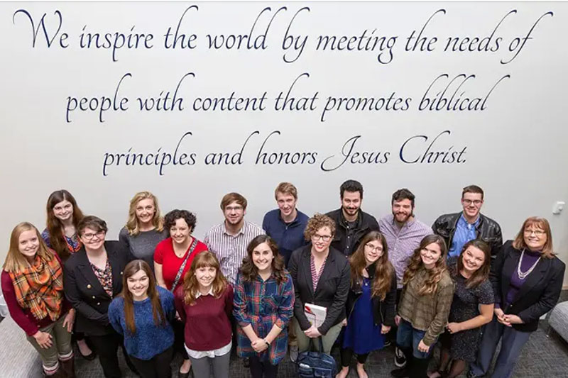 The group of Professional Writing students standing in front of a mural