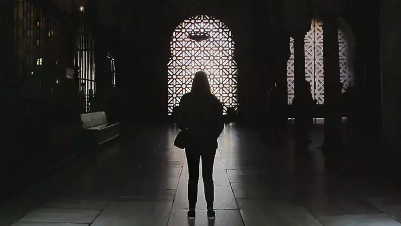 Female student silhouetted against a bright window in Spain