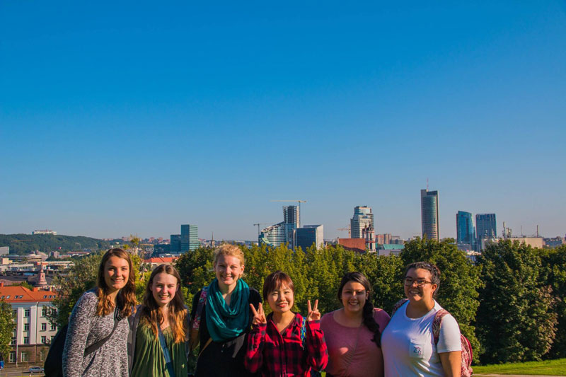 A group of Taylor Finance Majors posing in front of a skyline
