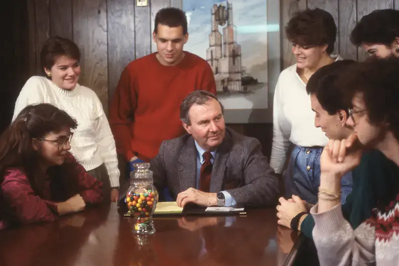 A group of students meeting with a faculty member in the 1980s