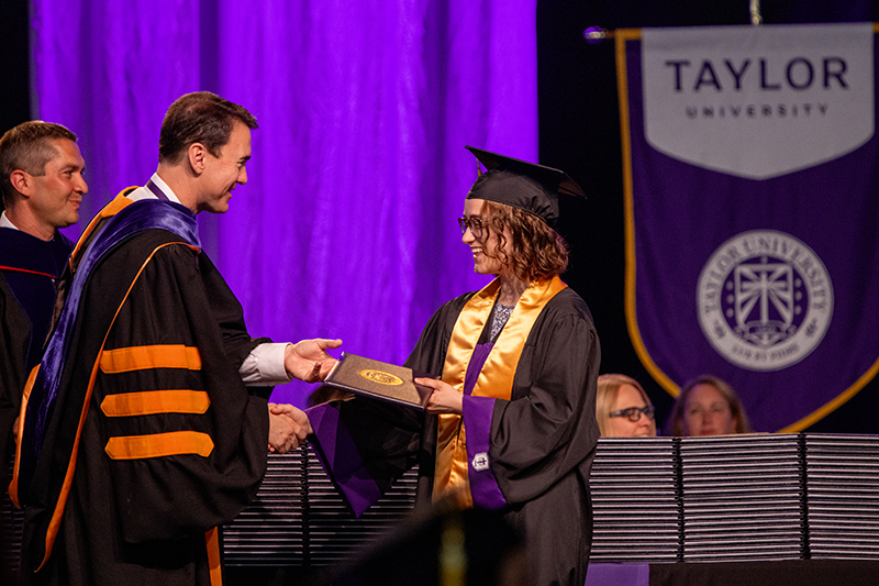 graduate accepts diploma from Taylor's president