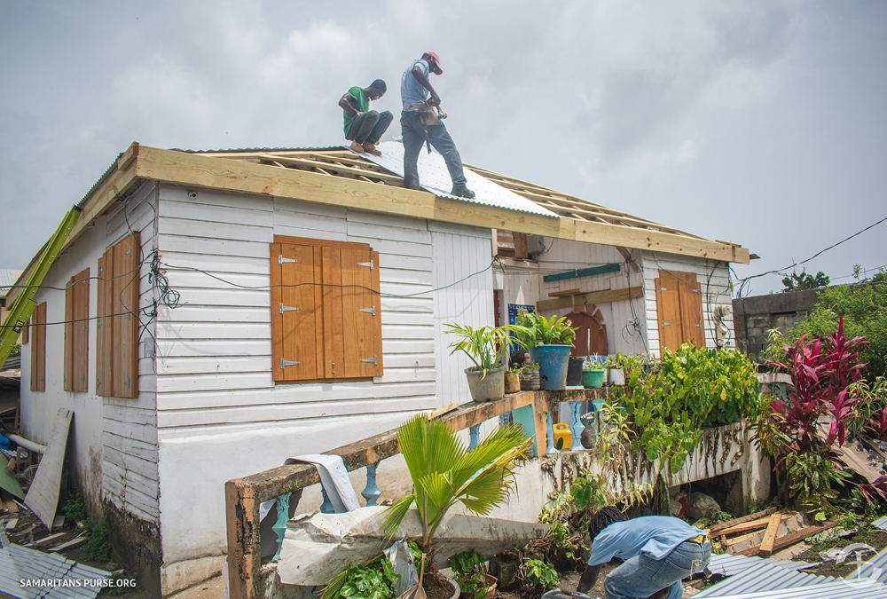 Workers finishing a roof on a house