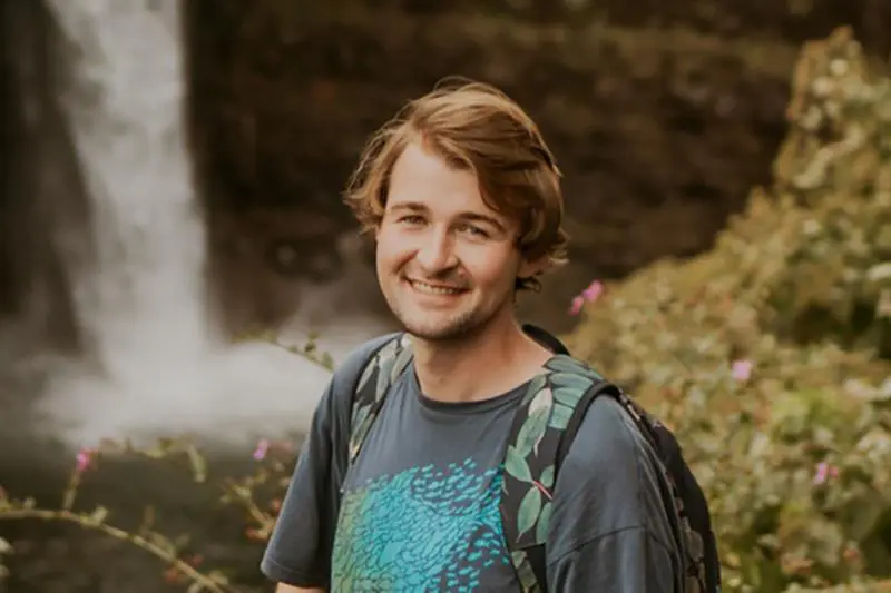 man stands in front of waterfall