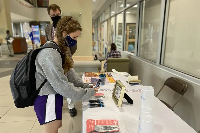 Student with their phone out at a table in the Student Center