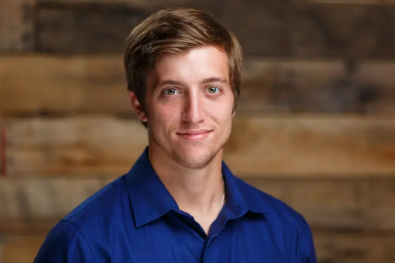 male student in front of wood background