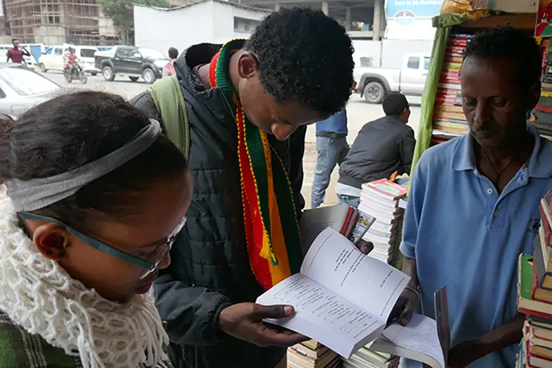 Gerber reading a book in a market