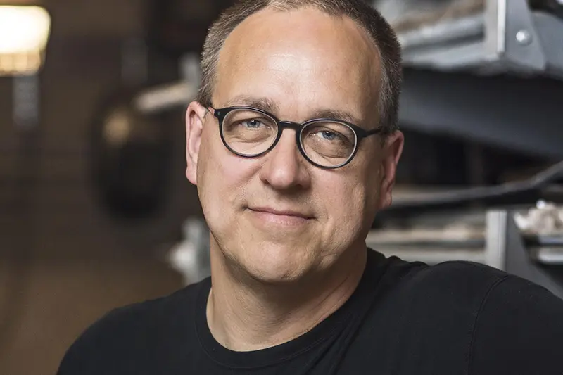 man with glasses standing in art workshop