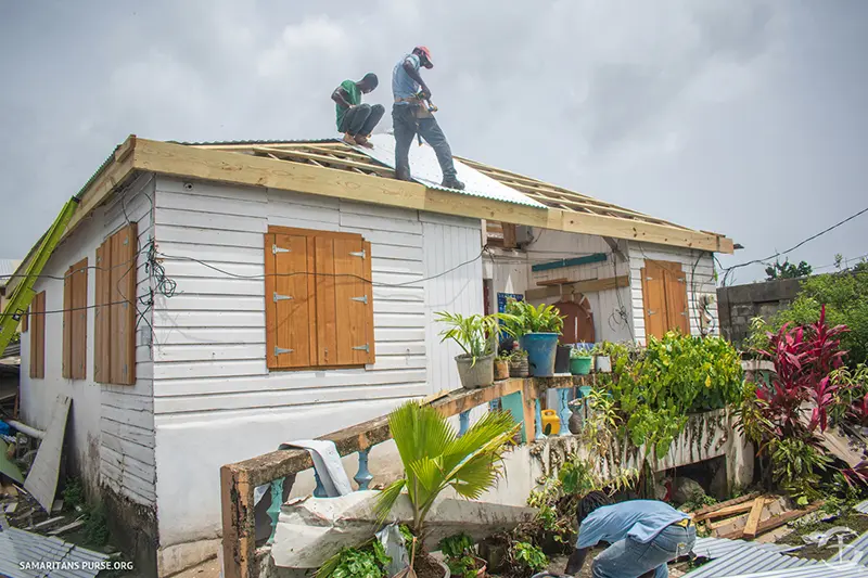 Workers finishing a roof on a house