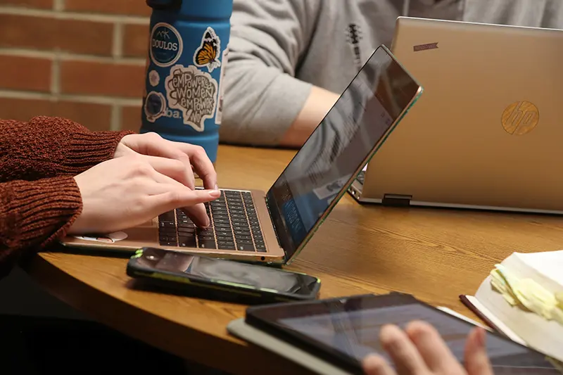 student using laptop and mobile phone