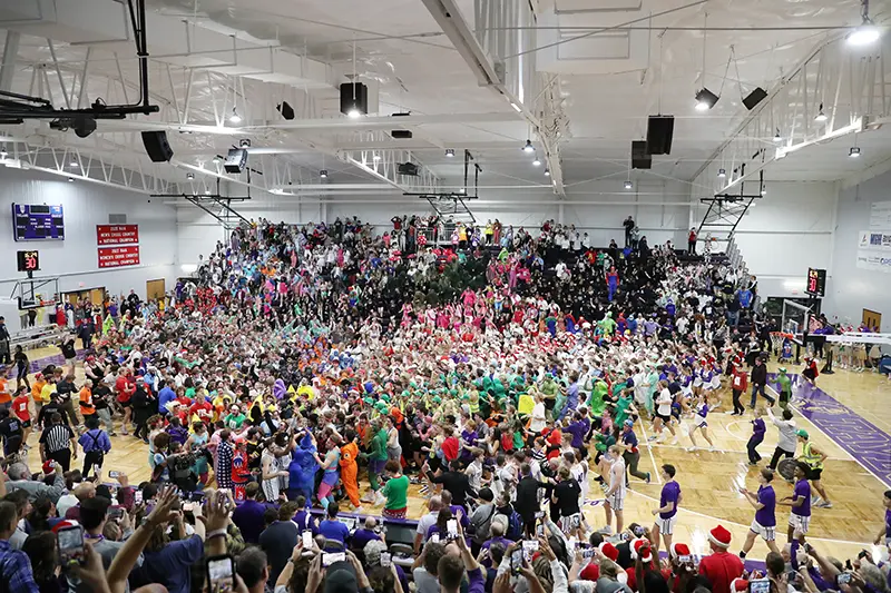 Students storm the basketball court at Silent Night