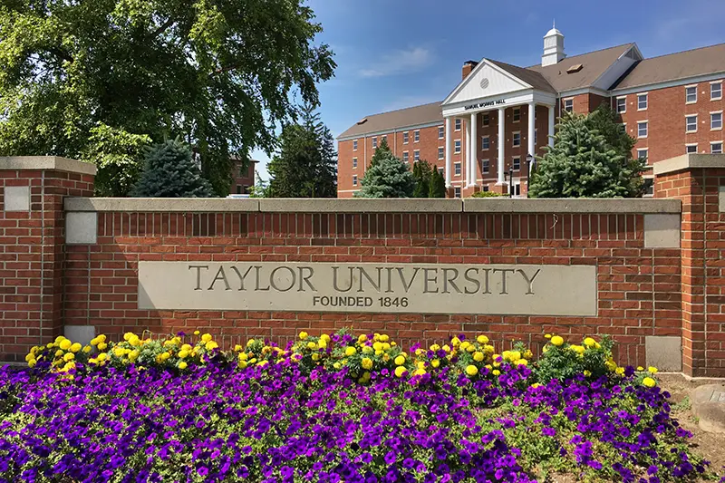 Sign with flowers in front of campus