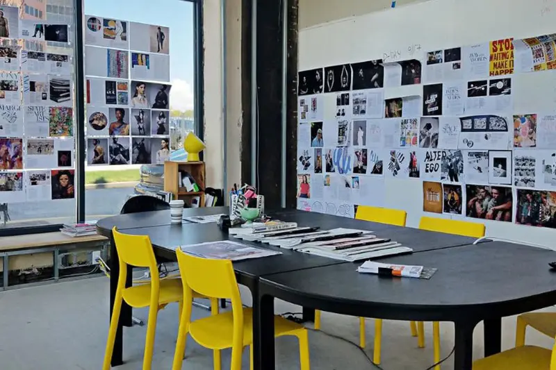 A group working table with many pictures on a board behind it